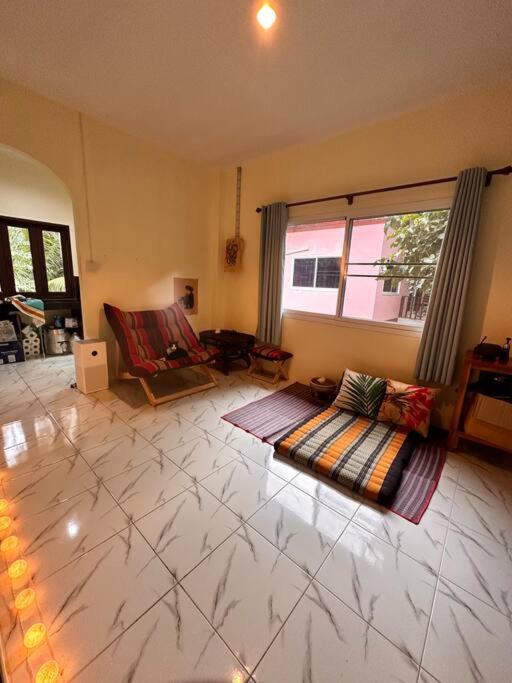 a living room with a rug on the floor at Cozy Garden House in Kohphangan! in Ban Nua