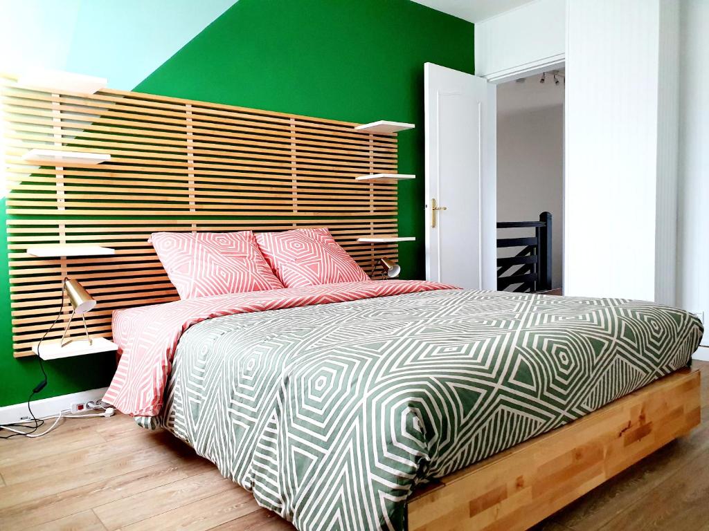 a bedroom with a bed and a green wall at Gîte de la valleuse, capacité 12 personnes, idéal pour une grande famille in Senneville-sur-Fécamp