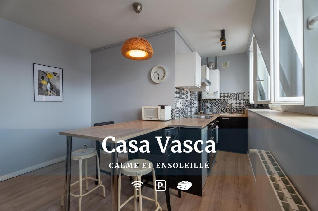cocina con mesa de madera en una habitación en CasaVasca - Appartement Cosy et Calme, WiFi - Parking, en Hendaya