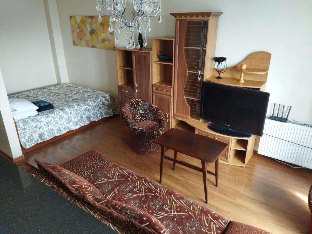 a bedroom with a bed and a desk with a television at Itaja Apartment 91 in Šiauliai