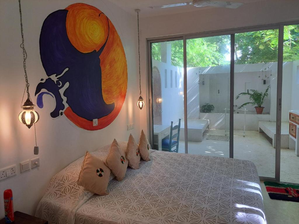 een slaapkamer met een bed met een schilderij aan de muur bij Manta Cottage - Forest view in Galu