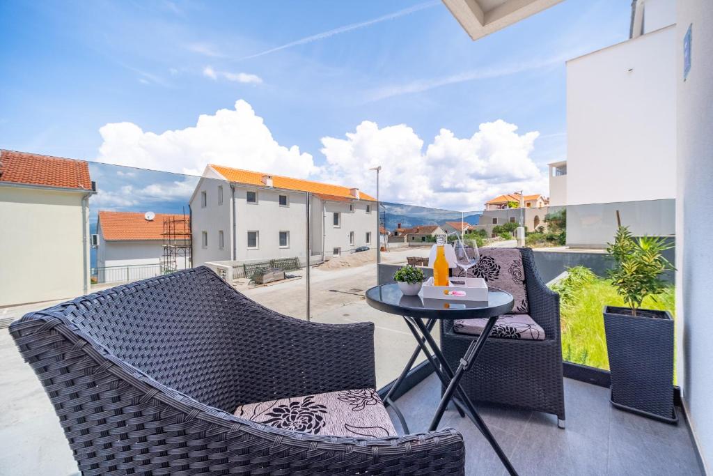 a patio with two chairs and a table on a balcony at Spacious one bedroom apartment Lana in Postira