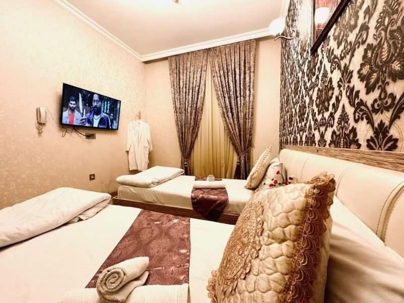 Cette chambre comprend 2 lits et une télévision. dans l'établissement Sebail Inn Hotel, à Baku