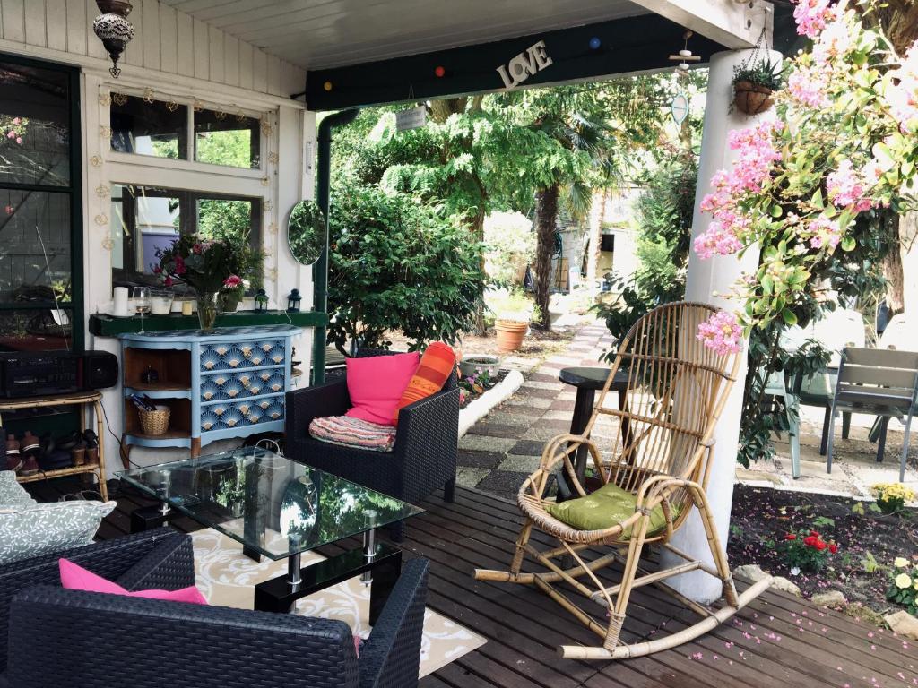 een patio met stoelen en een tafel op een veranda bij guesthouse bassin d'arcachon à la hume in Gujan-Mestras