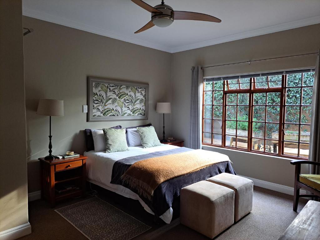 Schlafzimmer mit einem Bett und einem Deckenventilator in der Unterkunft Elvandar Country Cottage in Hilton