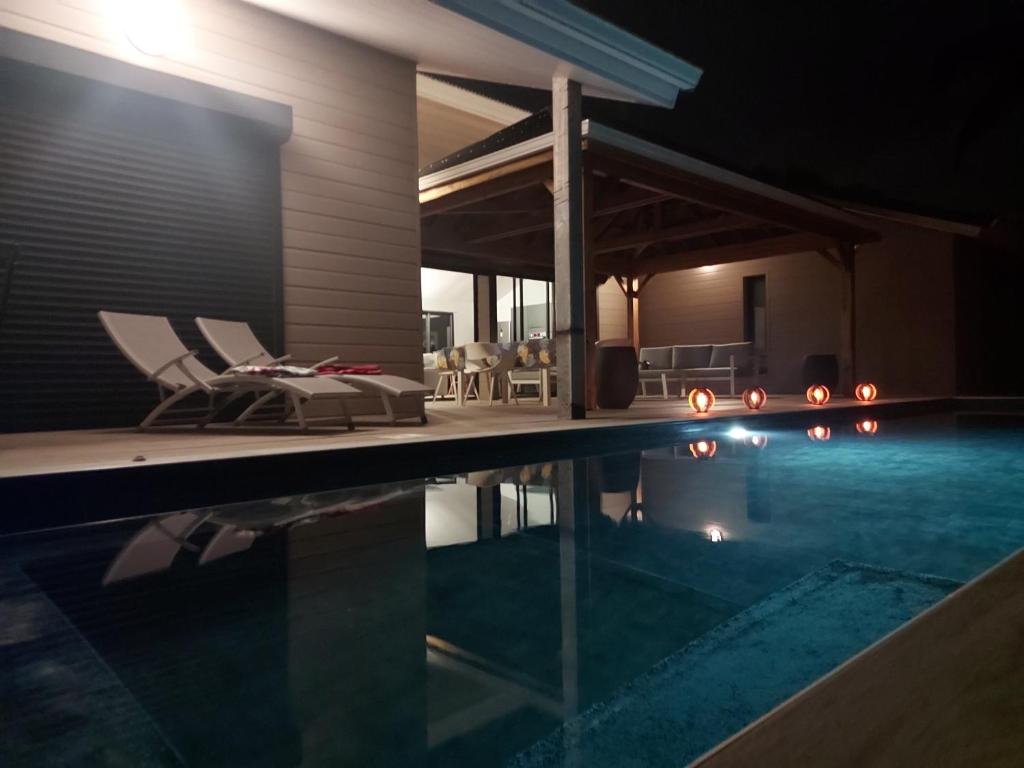 Villa con piscina por la noche en LE PETIT PARADIS en Sainte-Rose