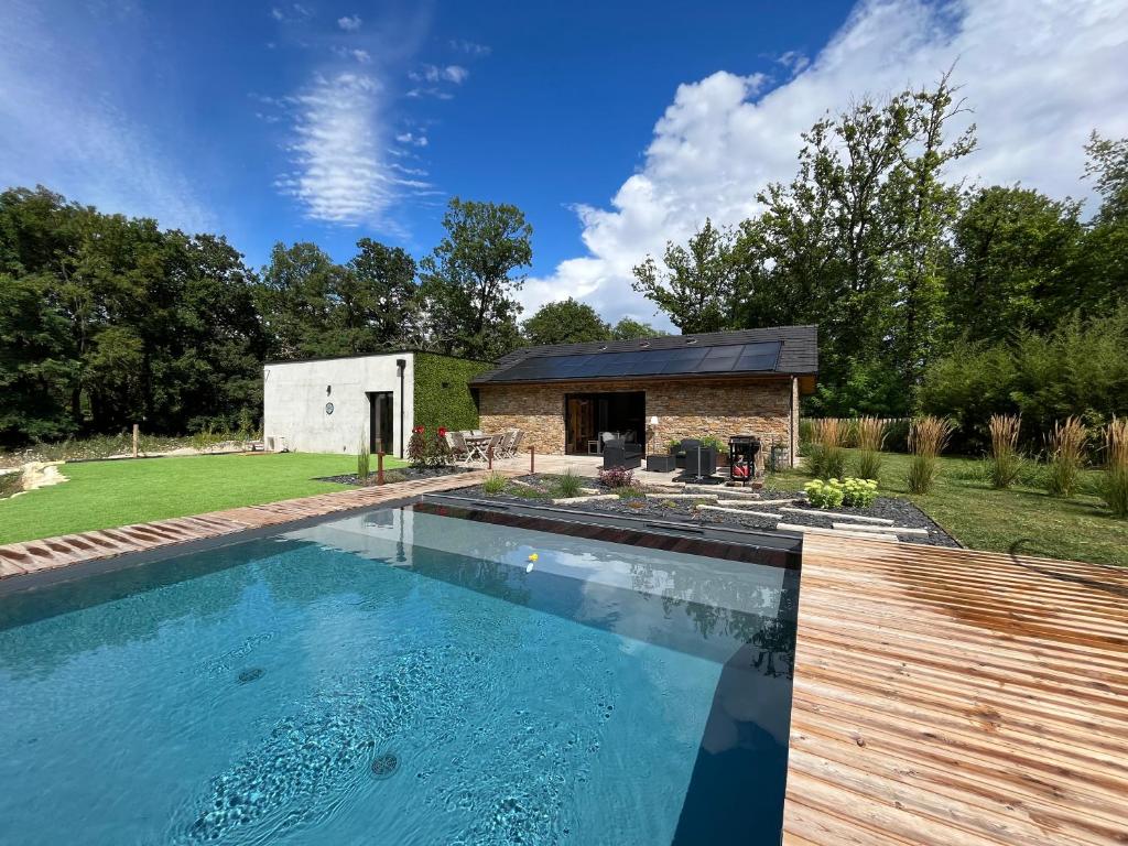 uma piscina num quintal com um edifício em La villa d'Eva em Léguillac-de-Lauche