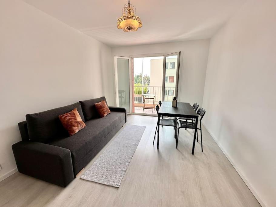 un salon avec un canapé noir et une table dans l'établissement Superbe appartement neuf - Plage à 5 min à pied, à Nice