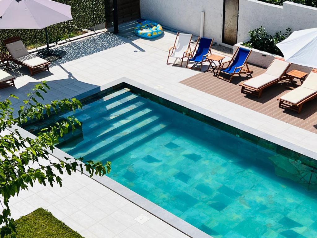 a swimming pool with chairs and umbrellas in a backyard at Villa Felix in Murter