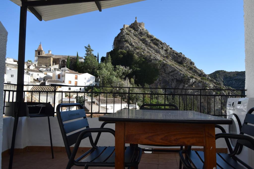 a table and chairs on a balcony with a view of a mountain at CASA DEL RIO in Castril