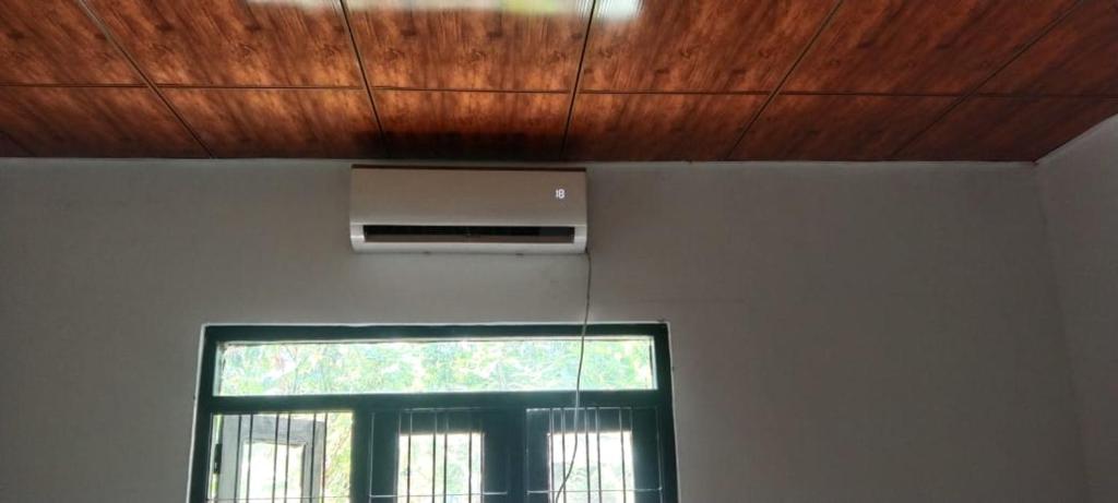 Cette chambre dispose d'une fenêtre et d'un plafond en bois. dans l'établissement Kitula family guest house, à Anurâdhapura