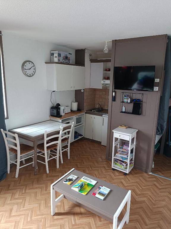 un salon avec une table et une cuisine dans l'établissement Les myrtilles La Pierre Saint Martin, à Arette