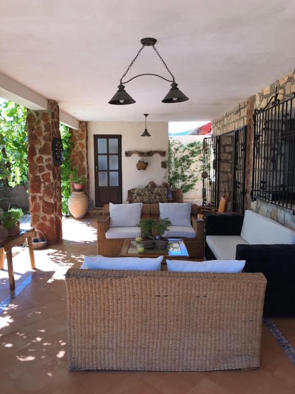 un patio con sofás, sillas y una mesa. en Casa de Piedra la Loma, en Calar de la Santa