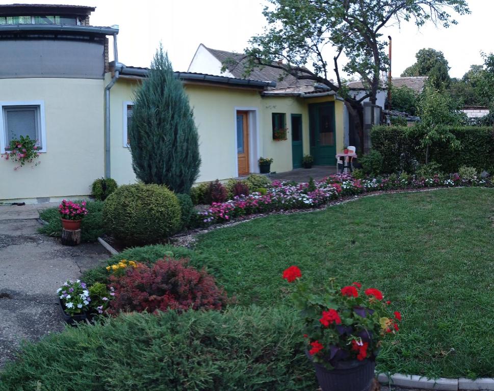 une maison avec un jardin fleuri dans la cour dans l'établissement Sobe Ana, à Sombor