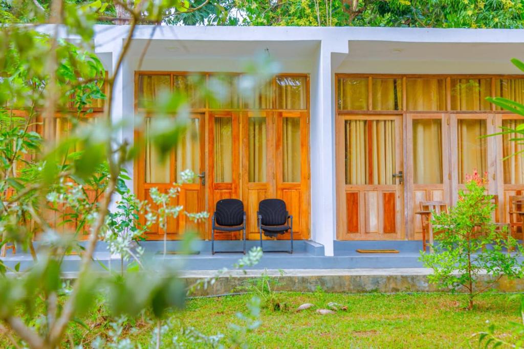two chairs sitting on the porch of a house at Talalla Ocean Beach Bungalow in Matara