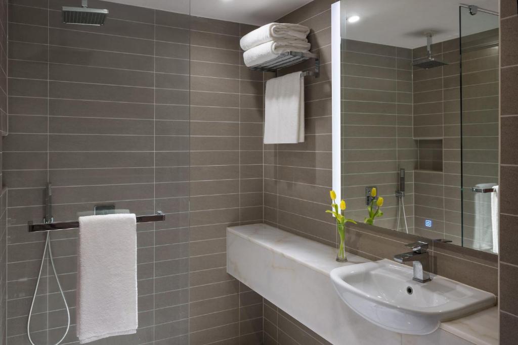 La salle de bains est pourvue d'un lavabo et d'un miroir. dans l'établissement voco Makkah an IHG Hotel, à La Mecque
