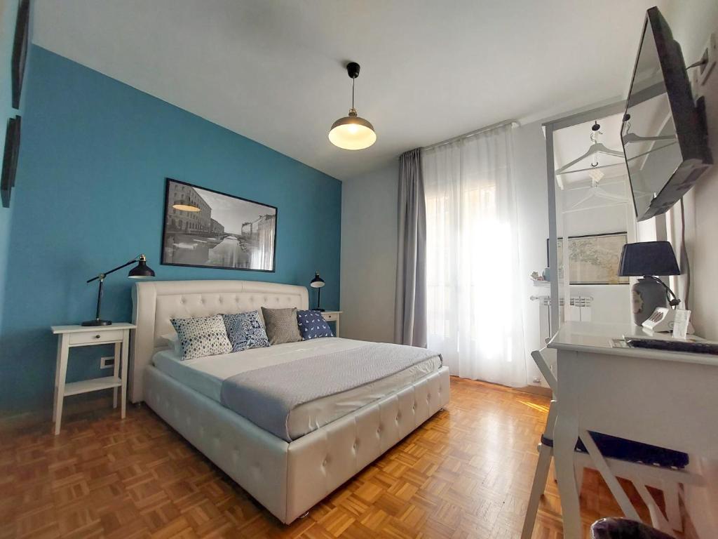 una camera con letto con pareti blu e scrivania di MyWay Trieste Rooms a Trieste