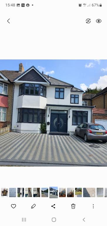 una casa blanca con un coche aparcado delante de ella en 64 Salmon Street en Londres