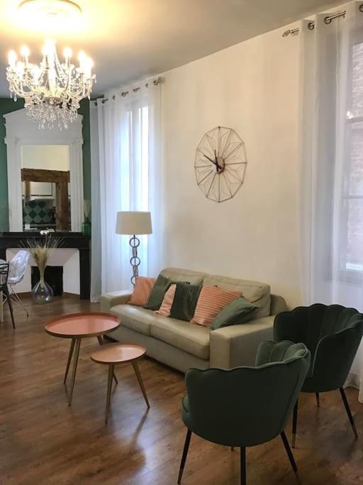 un salon avec un canapé, des tables et un réveil sur le mur dans l'établissement Hypercentre (avec parking), rare avec 3 chambres 3 salles d’eau, à Albi