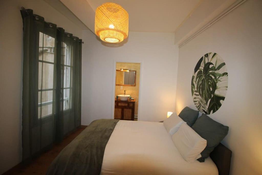 Un dormitorio con una cama grande y una ventana. en Hypercentre (avec parking), rare avec 3 chambres 3 salles d’eau, en Albi