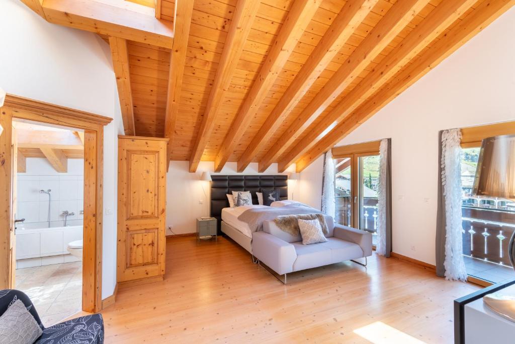 a bedroom with a bed and a wooden ceiling at Luxury Chalets & Apartments by Mountain Exposure in Zermatt