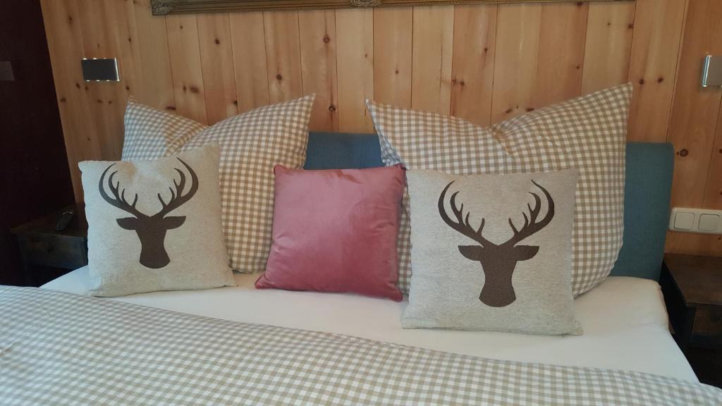 a bed with pillows with deer heads on it at Vogelsberger Zirbenstüberl in Grebenhain