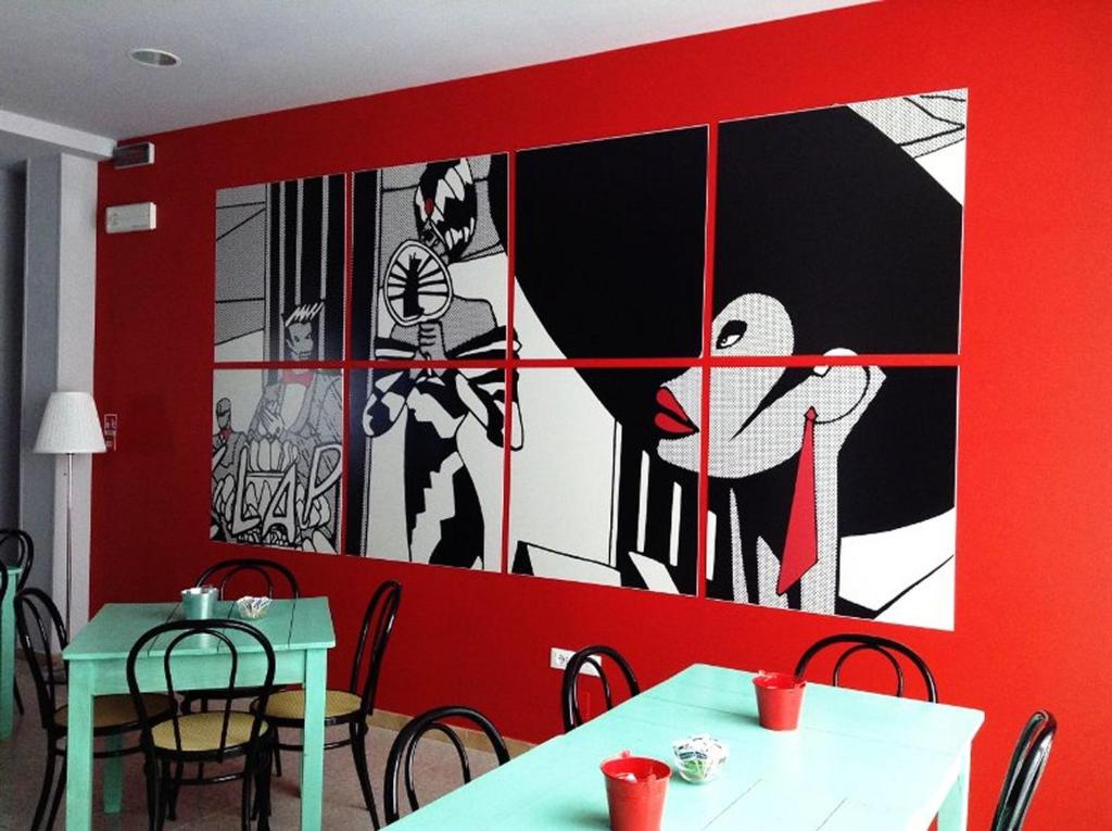 un comedor con 2 mesas y una pared roja en Hotel Byron Light NUOVA GESTIONE 2024, en Riccione