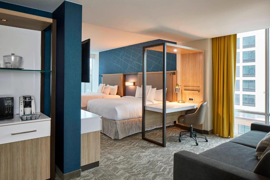 ナッシュビルにあるSpringHill Suites by Marriott Nashville Downtown/Convention Centerのベッド2台とデスクが備わるホテルルームです。