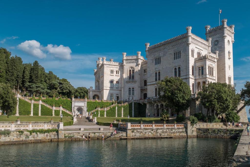 un castello con un lago di fronte di MyWay Trieste Rooms a Trieste
