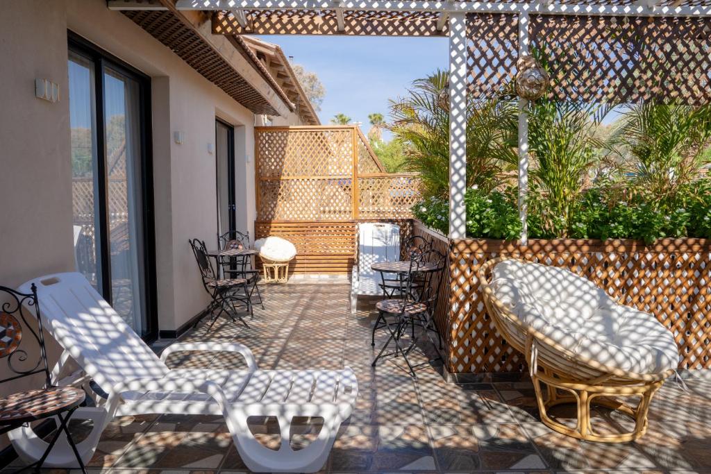 a patio with chairs and tables on a balcony at South Star Suites in Eilat