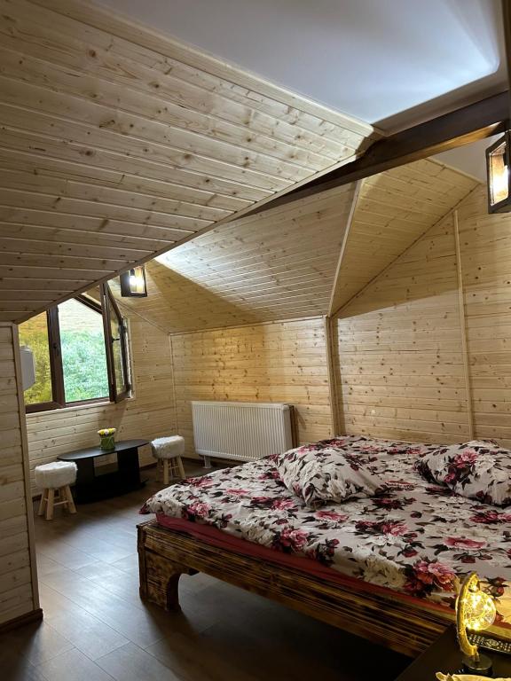 een slaapkamer met een bed in een houten kamer bij Cabana Rustic Sancel 
