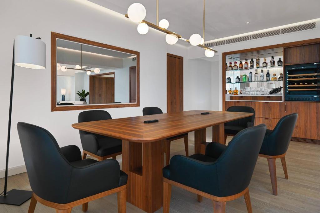 a dining room with a wooden table and chairs at Malta Marriott Resort & Spa in St. Julianʼs