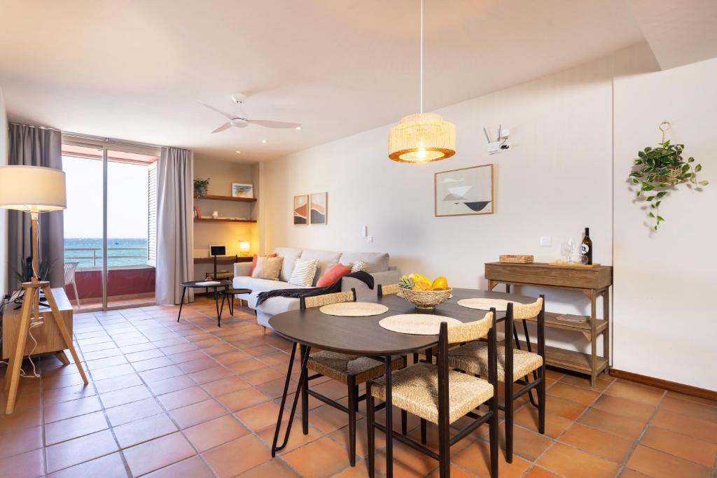 - un salon avec une table, des chaises et un canapé dans l'établissement Spectacular Beachfront Loft-Style CASA CORINA II, à El Médano