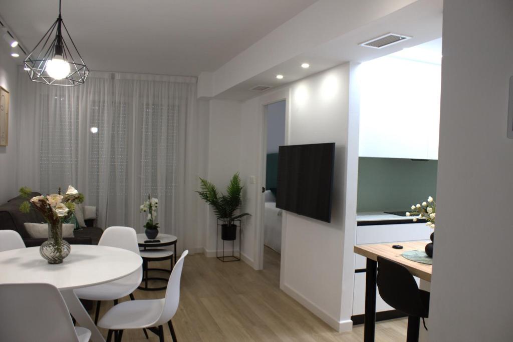ein Esszimmer und ein Wohnzimmer mit einem weißen Tisch und Stühlen in der Unterkunft Apartamento Granada-Ronda in Granada