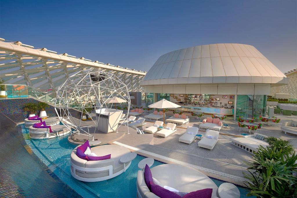 a resort with a pool with chairs and tables and a swimming pool at W Abu Dhabi - Yas Island in Abu Dhabi