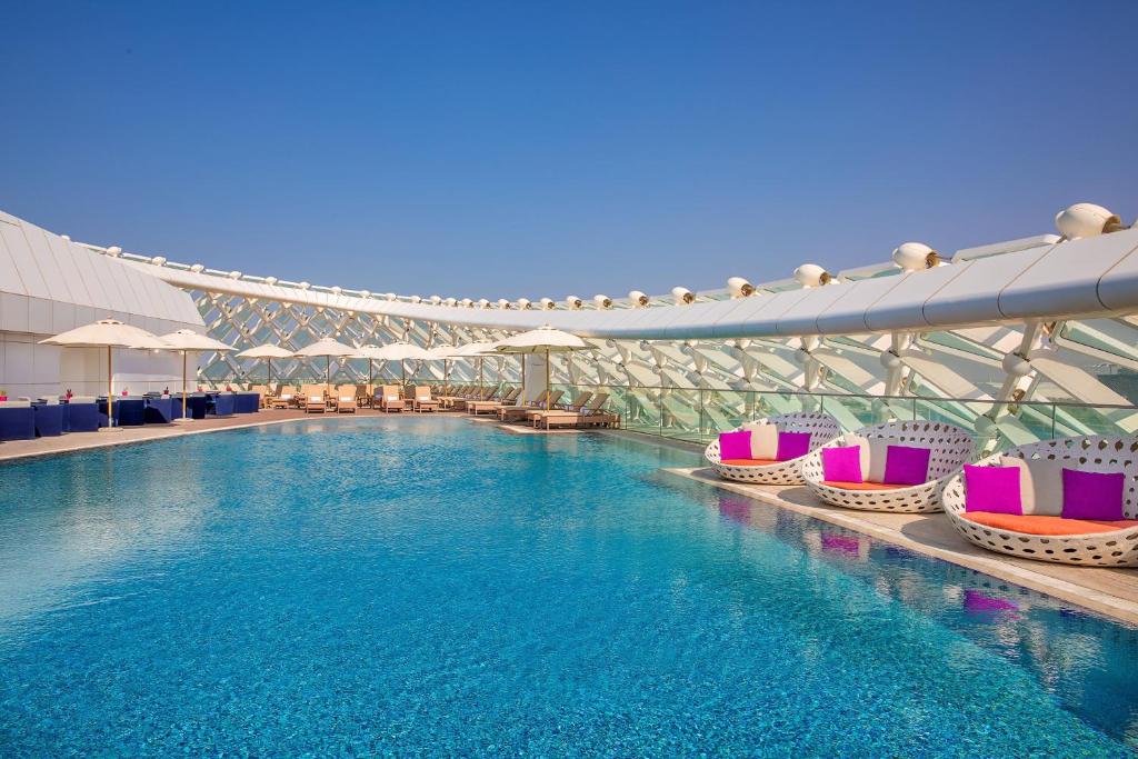 einen Pool mit bunten Stühlen in einem Gebäude in der Unterkunft W Abu Dhabi - Yas Island in Abu Dhabi
