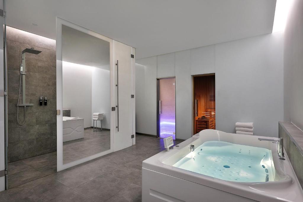 a bathroom with a tub and a shower and a sink at W Abu Dhabi - Yas Island in Abu Dhabi