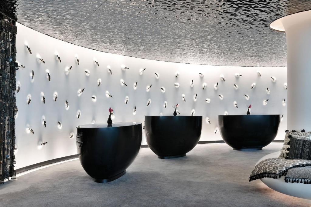 a room with three black bowls against a wall at W Abu Dhabi - Yas Island in Abu Dhabi