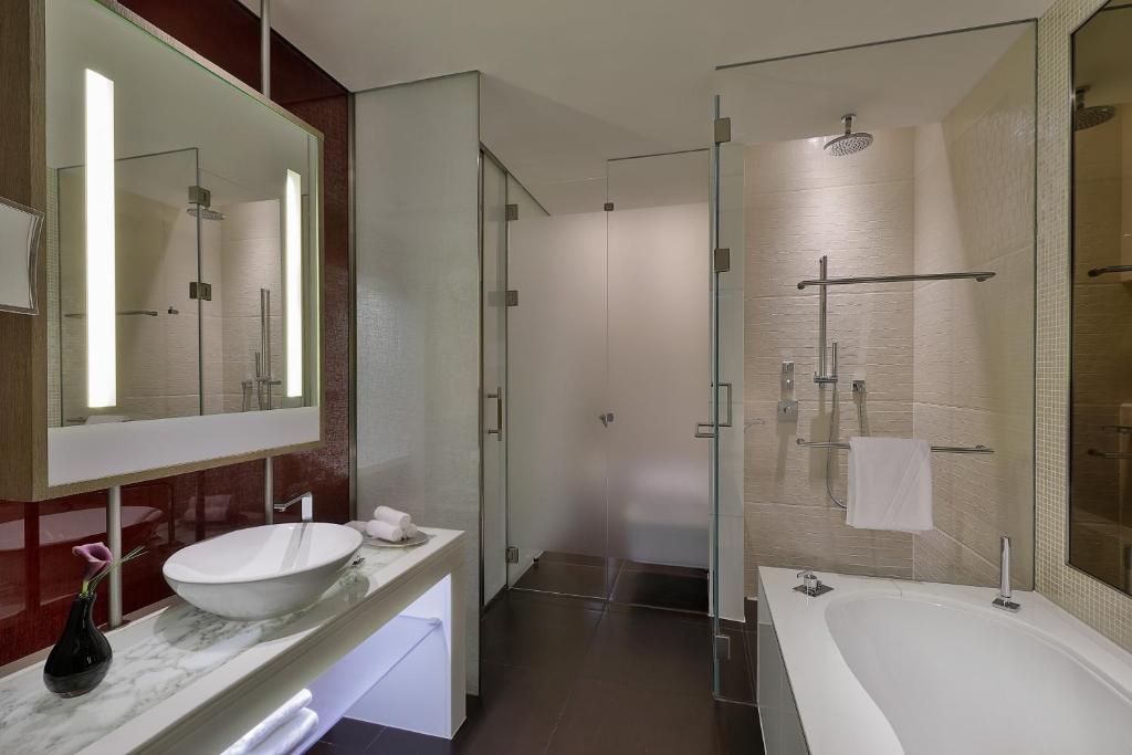 a bathroom with a tub and a sink and a mirror at W Abu Dhabi - Yas Island in Abu Dhabi