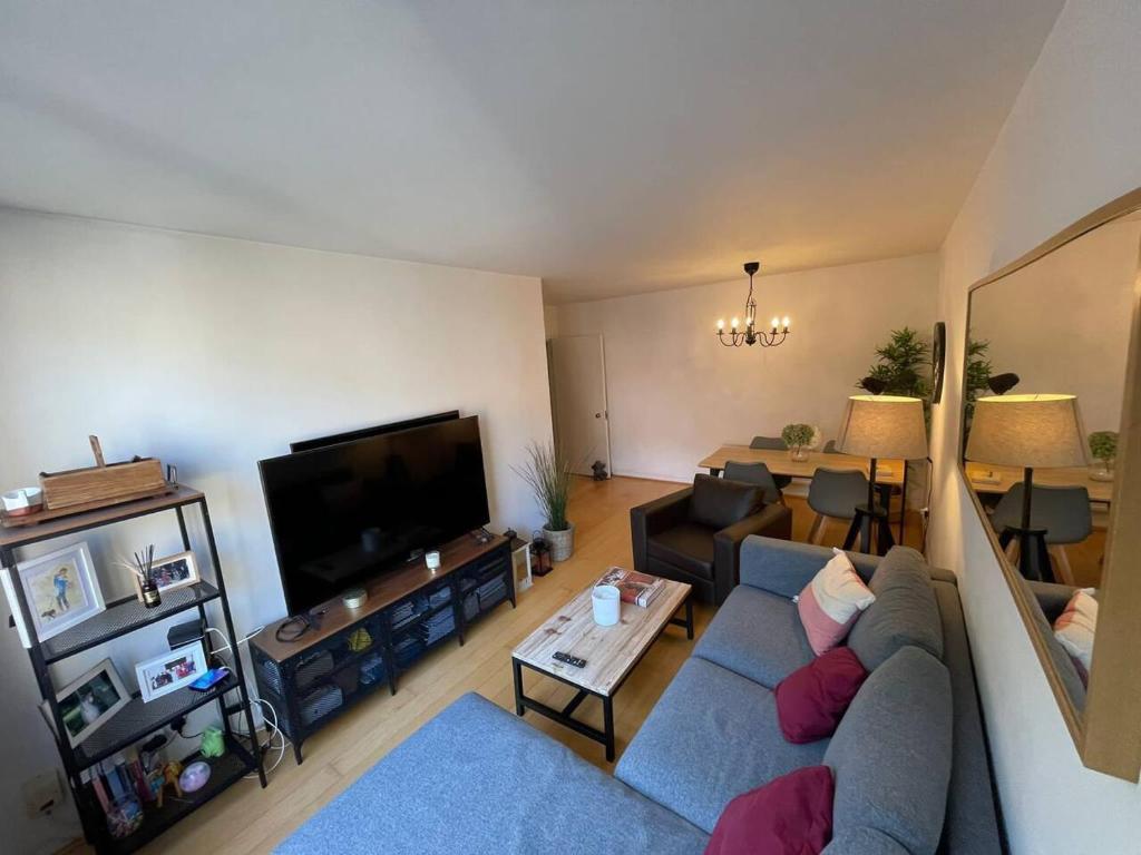 ein Wohnzimmer mit einem blauen Sofa und einem TV in der Unterkunft Refurbished central apartment in London