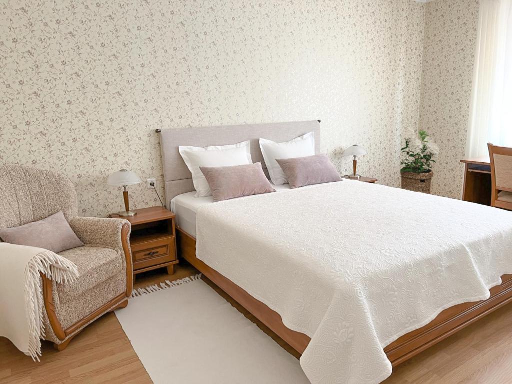 a bedroom with a large bed and a chair at Margate Accommodation in Haapsalu