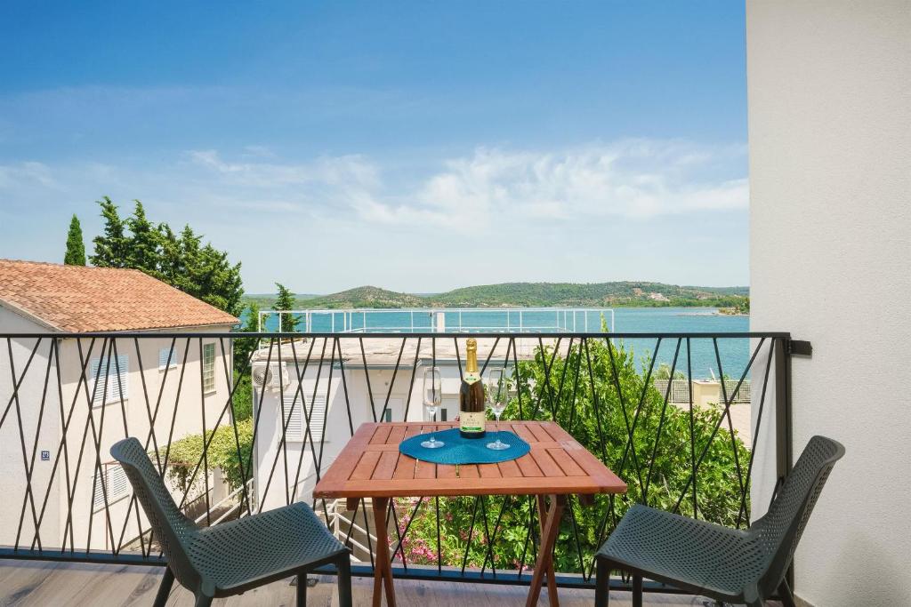 uma mesa e cadeiras numa varanda com vista para o oceano em Apartments Picikato em Bilice