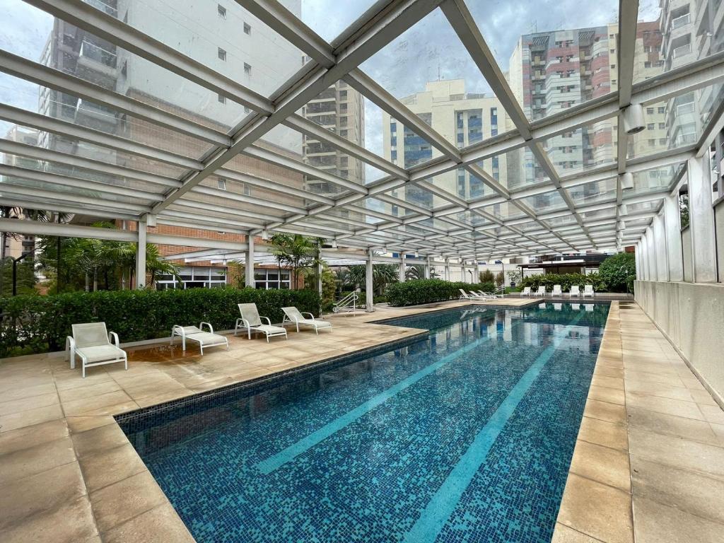 uma grande piscina com tecto de vidro em Studio Deluxe - Dot 173 em Campinas