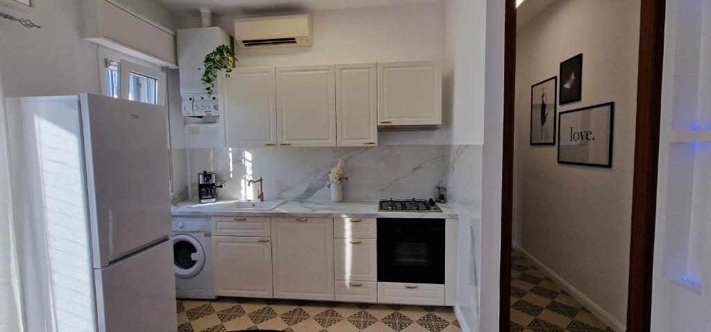 eine Küche mit weißen Schränken, einer Waschmaschine und einem Trockner in der Unterkunft Residence Euromare in Cesenatico