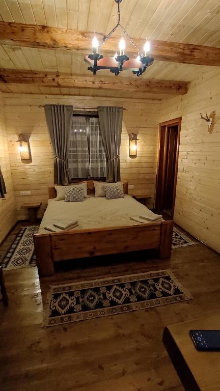 a bedroom with a large bed in a cabin at Casa de Lemn Maramures in Mara