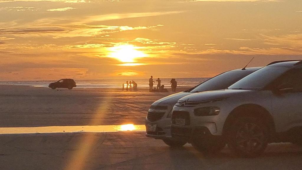 a car parked on a beach with the sunset at Casa Praia do Atalaia em Salinas Pará in Salinópolis