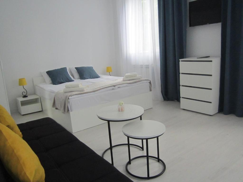 biała sypialnia z łóżkiem i dwoma stołami w obiekcie Vernatun guest house w mieście Giumri