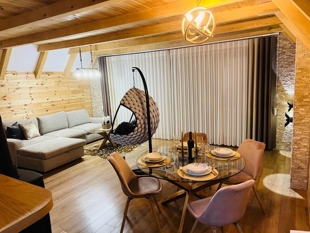 a living room with a table and chairs and a couch at Prima Vista in Žabljak