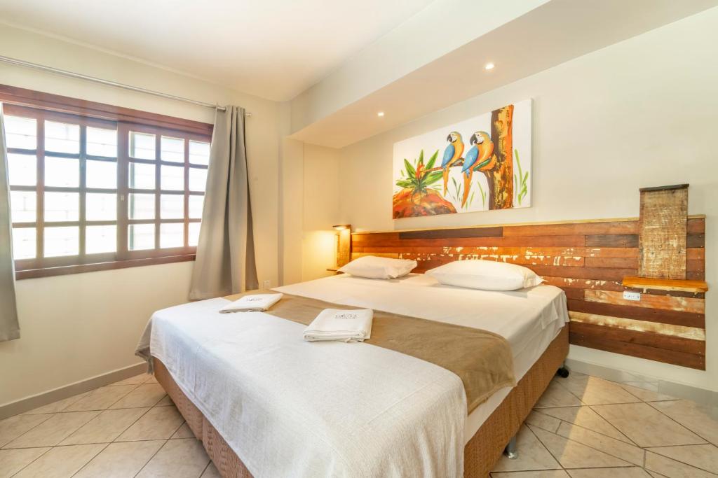 1 dormitorio con 2 camas y ventana en Pousada Gruta do Monge, en Bombinhas