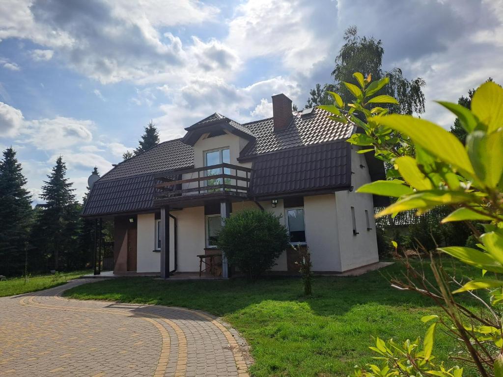 a white house with a black roof at Dom nad jeziorem 